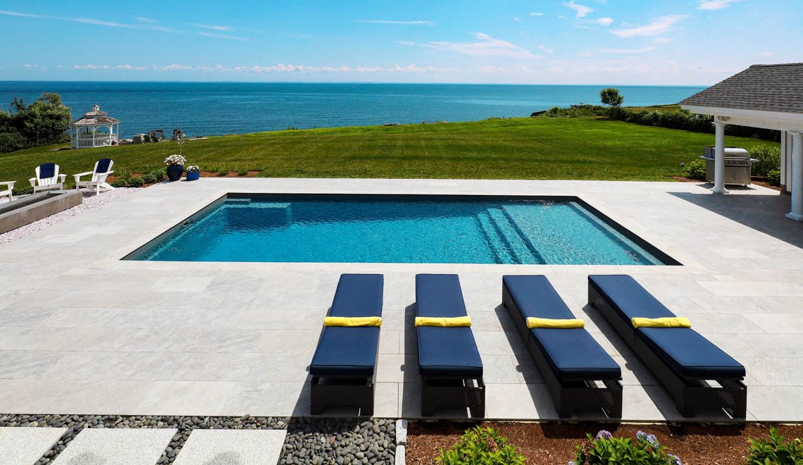 Northern Colorado Pools shows a backyard pool area made for comfort, quality, and relaxing views by the ocean.