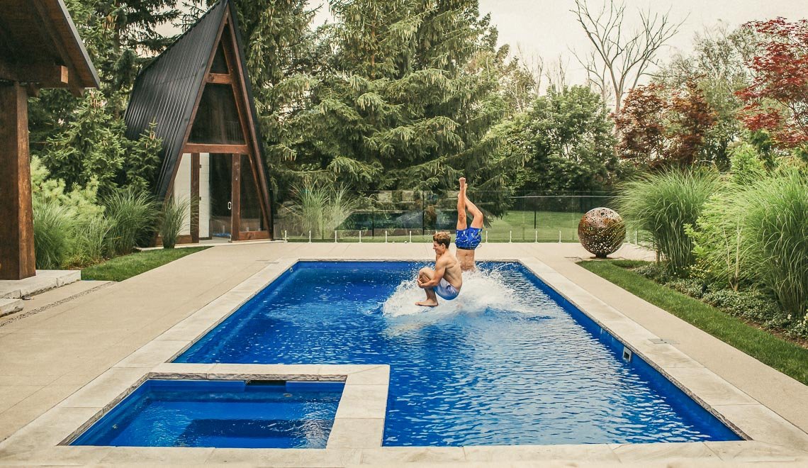 Kids enjoying a splash at a Northern Colorado Pools backyard, showing fun and quality pool design for family homes.