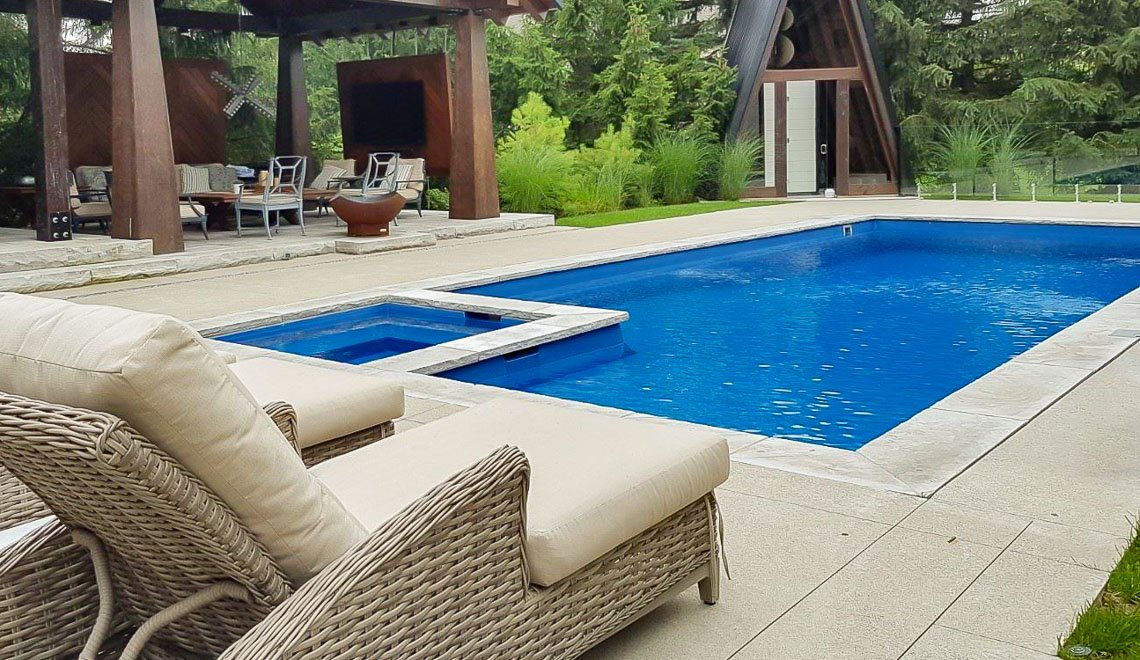 Northern Colorado Pools creates relaxing, easy-care backyard spaces with pool, hot tub, and seating for family enjoyment.