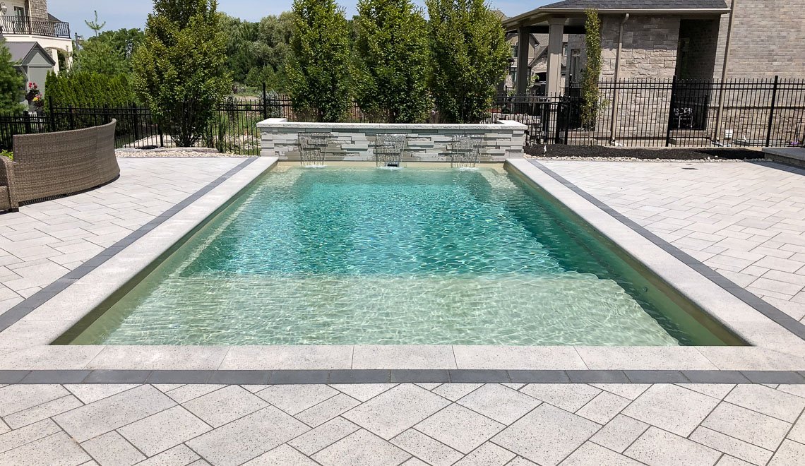 Northern Colorado Pools' backyard design highlights a modern, clean pool in a peaceful and welcoming setting.