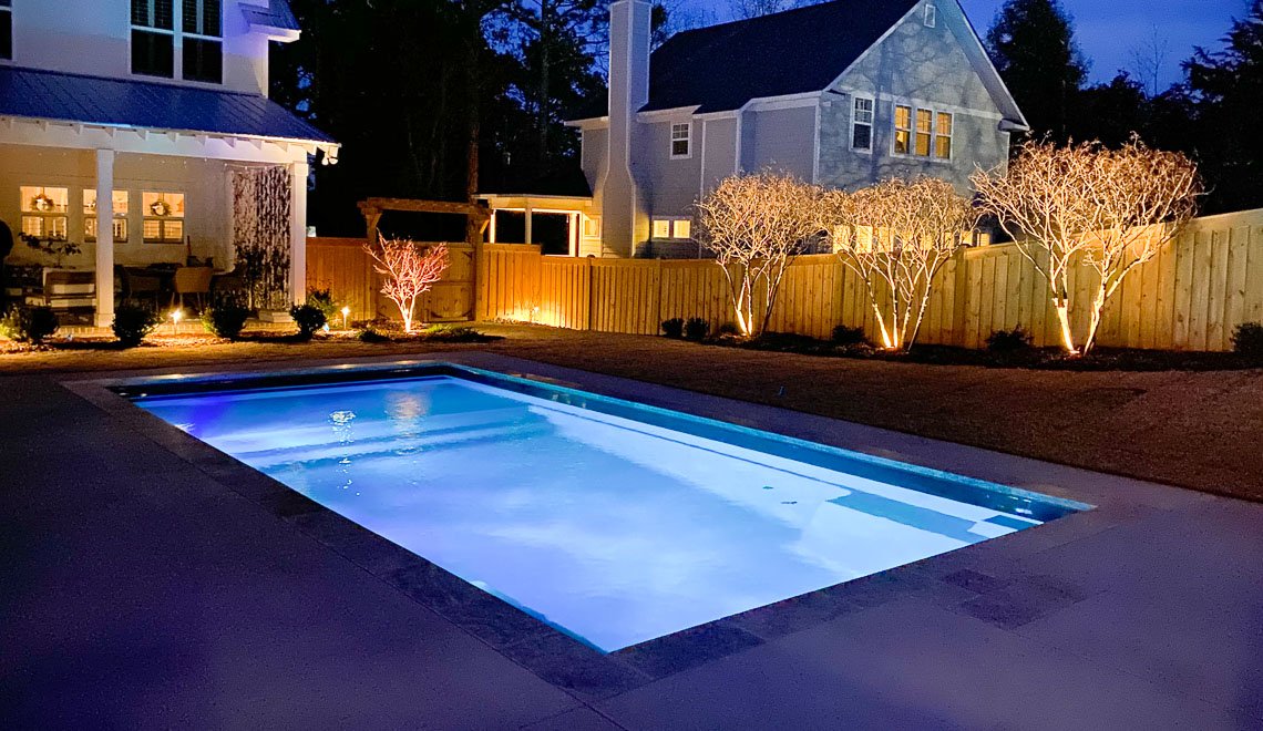 A backyard pool by Northern Colorado Pools looks inviting at dusk, showing off expert design and a relaxing evening mood.